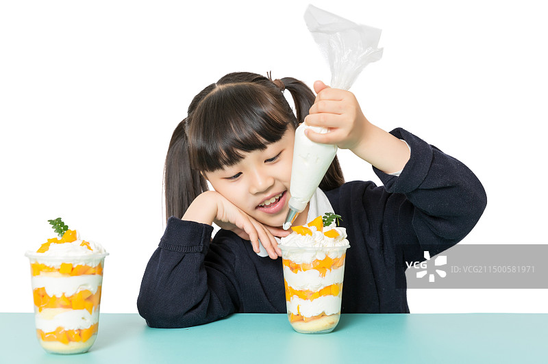 小女孩手拿裱花袋挤奶油制作甜品图片素材