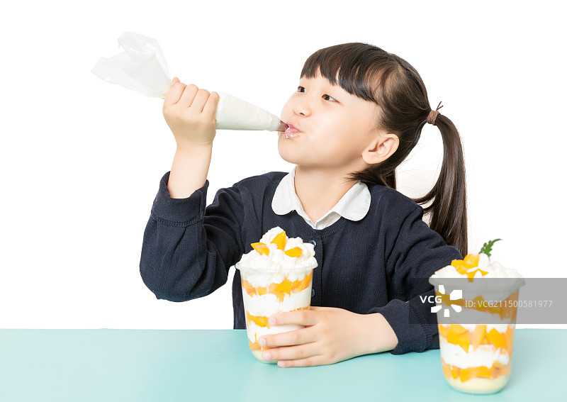 小女孩手拿裱花袋挤奶油制作甜品图片素材