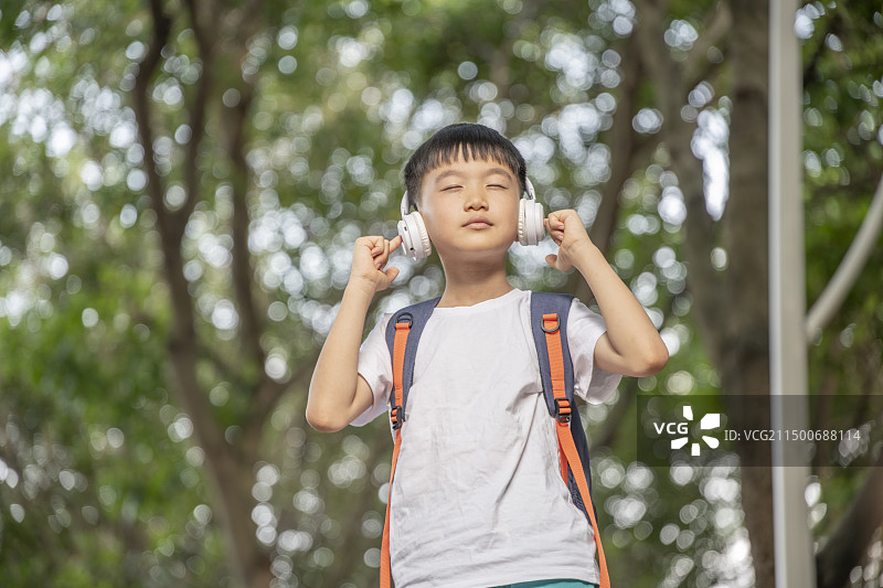 头戴耳机静静地享受音乐的小男孩图片素材