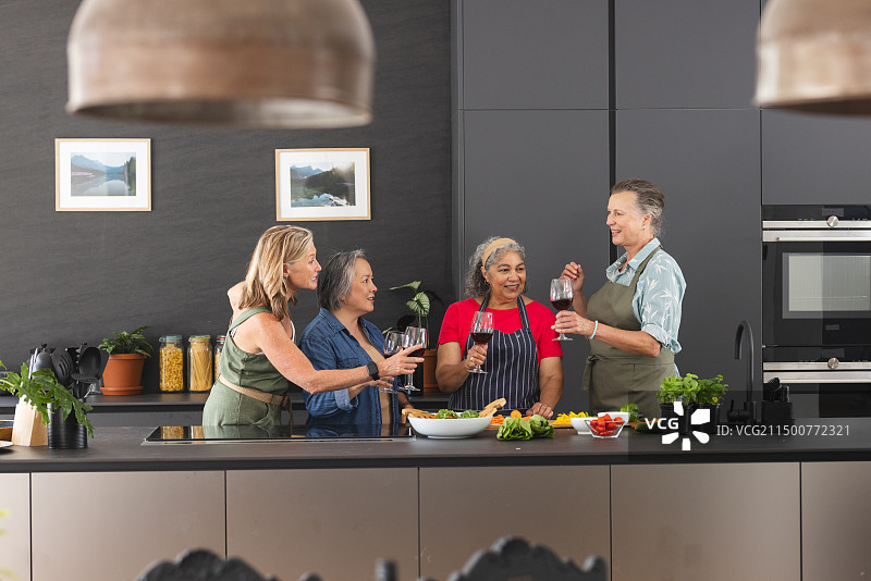 各类的资深女性朋友捧着酒杯，在家里开怀大笑图片素材