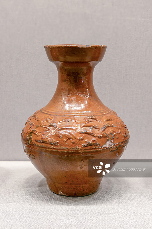 北京故宫武英殿陶瓷馆-酱黄釉凸刻狩猎纹盘口陶壶-东汉图片素材