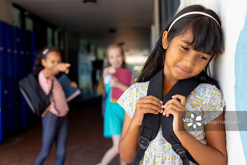 混血女孩靠在蓝色背景上，面对应对校园暴力图片素材