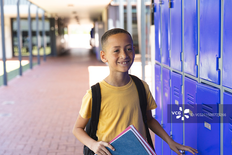 在学校走廊里微笑的混血男孩图片素材