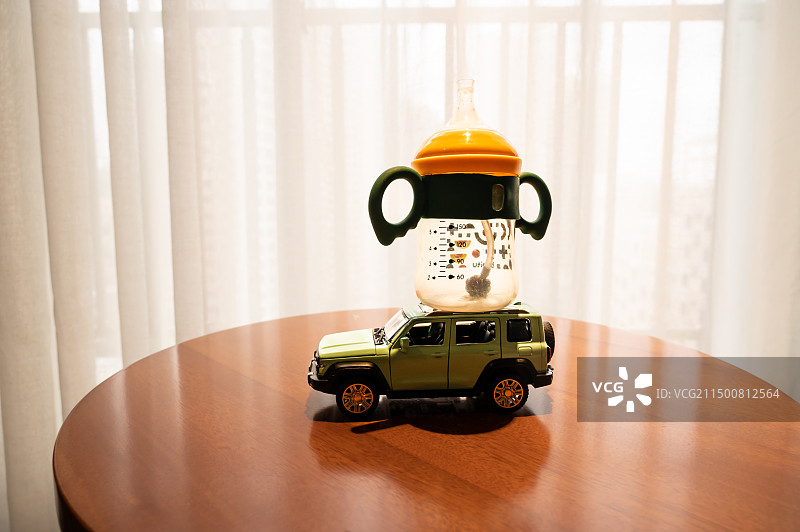静物越野汽车玩具模型和儿童奶瓶图片素材