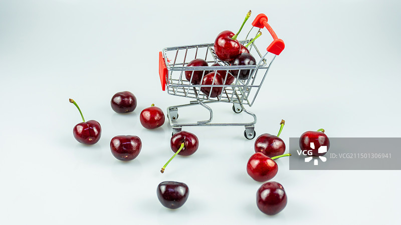 白色背景下购物车中的樱桃特写镜头图片素材