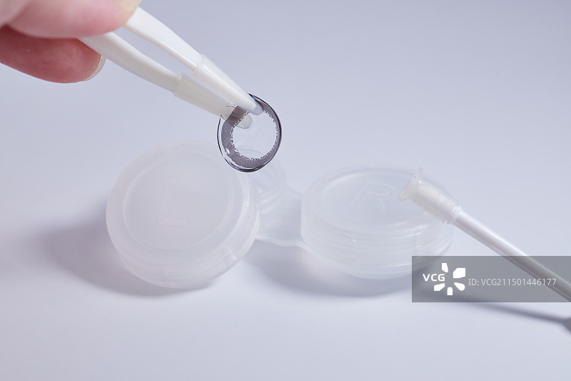 白色背景上手持隐形眼镜的特写镜头图片素材