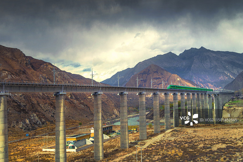山谷间，大桥横跨，拉林铁路上动车飞驰。图片素材