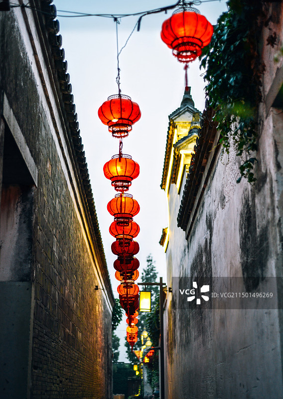 宁波镇海区澥浦镇郑氏十七房景区的明清古建筑风景：窄巷子里的白色墙壁与红色灯笼图片素材