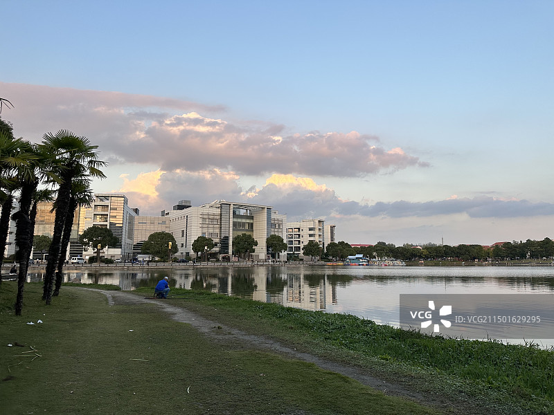 上海美兰湖，阳光照耀的云，平静的湖面，和美兰湖国际会议中心的倒影图片素材