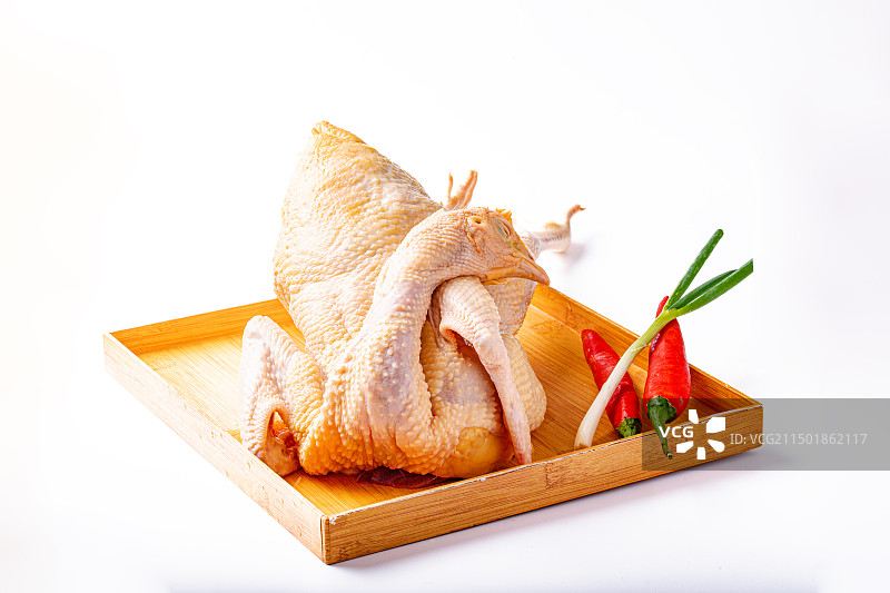 棚拍白底竹盘里新鲜宰杀好的小母鸡图片素材