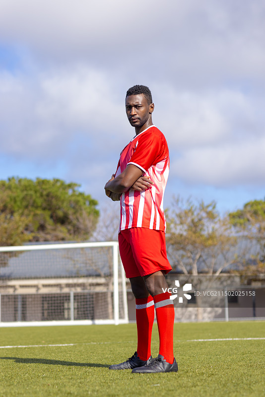 自信地站在足球场上的非裔美国足球运动员图片素材