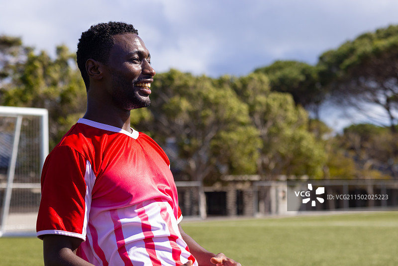 穿着红色运动服的非裔美国男性健身教练在户外微笑图片素材