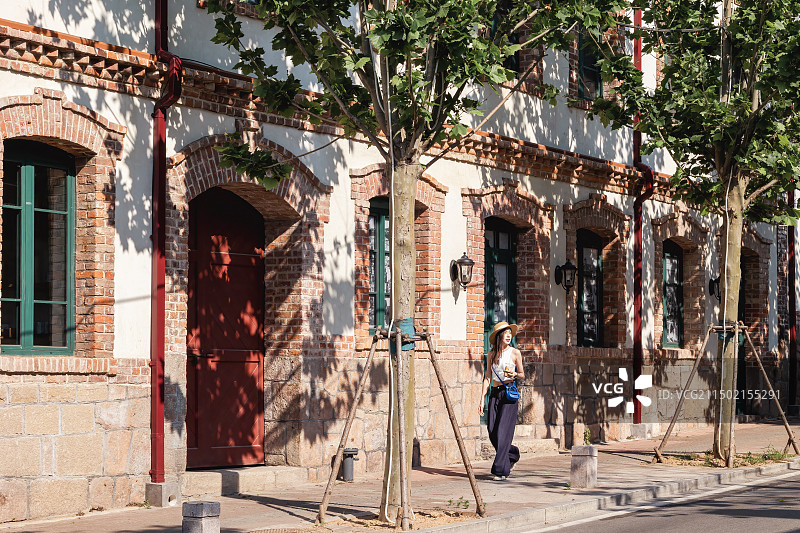 青岛中山路德式建筑前站走过的女人图片素材