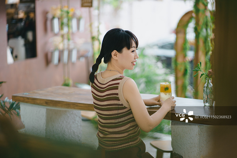 在网红店喝下午茶享受生活的年轻女人图片素材