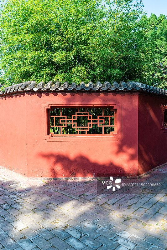 中国山东泰安著名景点泰山旅行旅游目的地，泰山第一行宫岱庙，素景中式庭院里的月亮门和花坛，户外白昼无人图片素材