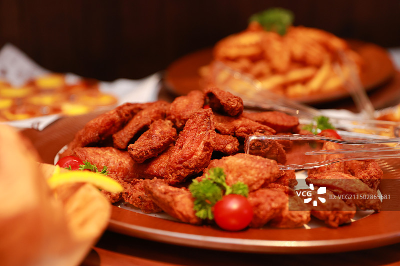 桌上盘子里装满炸鸡翅食物的特写镜头图片素材