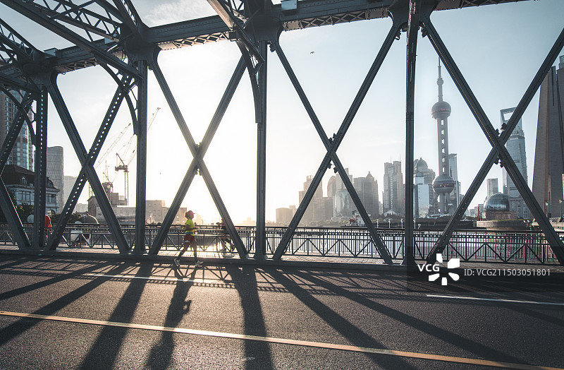 白昼晴天逆光的钢铁经典古典建筑及道路，上海外白渡桥与城市天际线图片素材