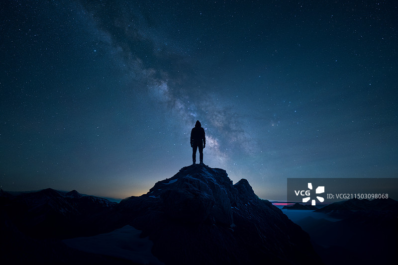 一个人的背影站在山顶上，眺望银河图片素材