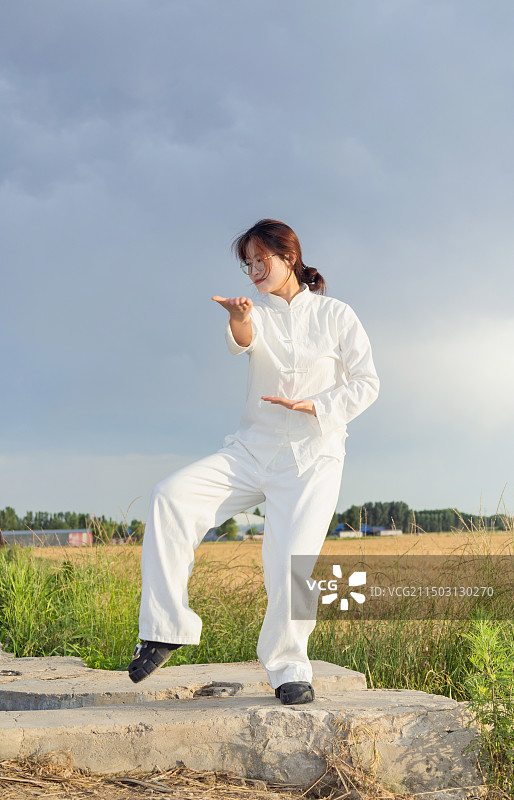 户外女孩穿着练功服做太极八段锦动作的全身人像图片素材