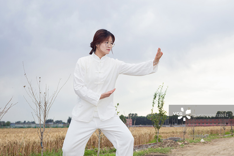 户外女孩穿着练功服做太极八段锦分解动作图片素材