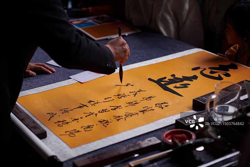 在桌子上写中国书法的人图片素材