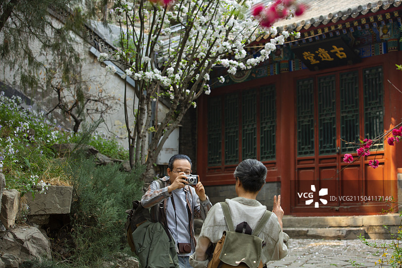老年人City walk系列:老年夫妻在北京北海公园旅行拍照图片素材