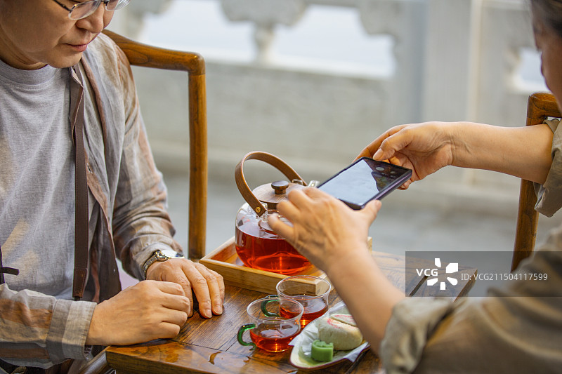 老年人City walk系列:老年夫妇在北京什刹海茶馆里喝茶拍照特写图片素材
