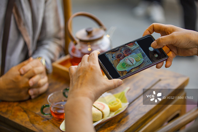 老年人City walk系列:老年夫妇在北京什刹海茶馆里喝茶拍照特写图片素材