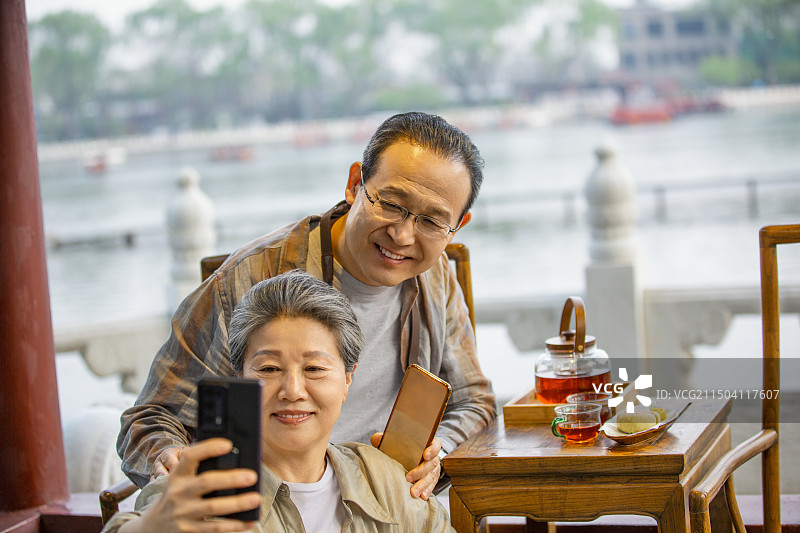 老年人City walk系列:老年夫妇在北京什刹海茶馆里喝茶自拍图片素材