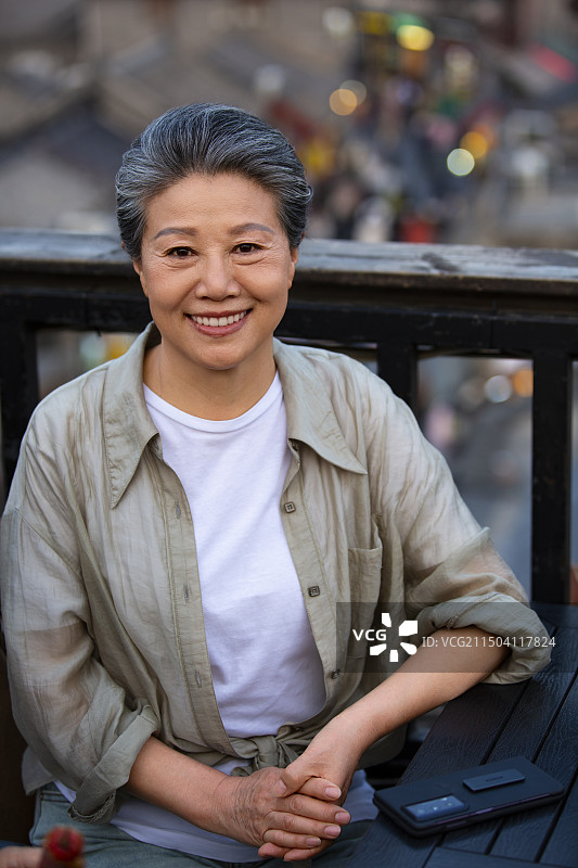 老年人City walk系列:老年女人在北京什刹海咖啡店的屋顶休息图片素材