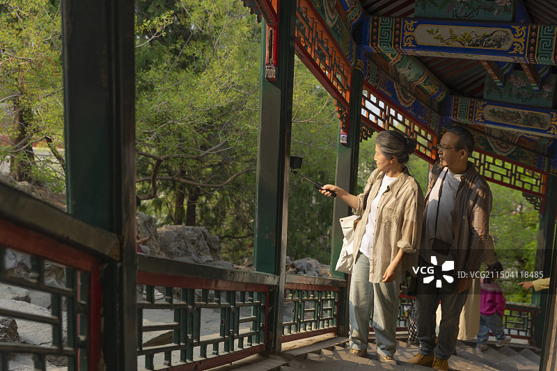 老年人City walk系列:老年夫妻在北京北海公园旅行拍照图片素材