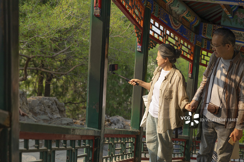 老年人City walk系列:老年夫妻在北京北海公园旅行拍照图片素材