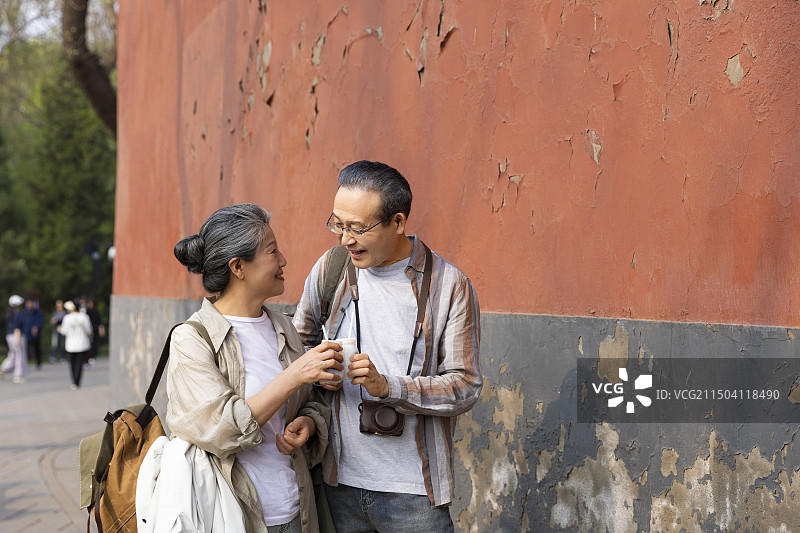 老年人City walk系列:老年夫妻在北京北海公园旅行喝酸奶图片素材