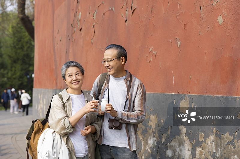 老年人City walk系列:老年夫妻在北京北海公园旅行喝酸奶图片素材