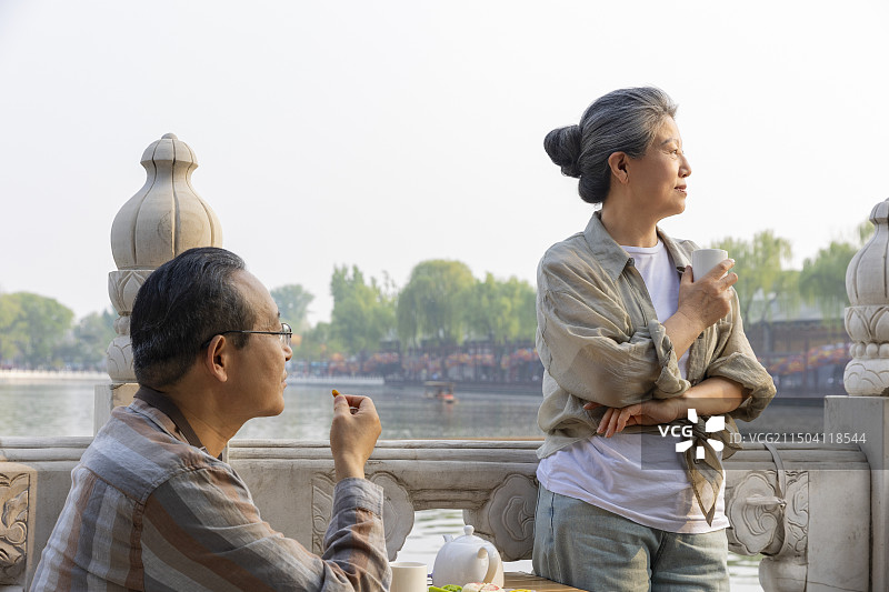 老年人City walk系列:老年夫妇在北京什刹海喝茶、吃茶点、看风景图片素材