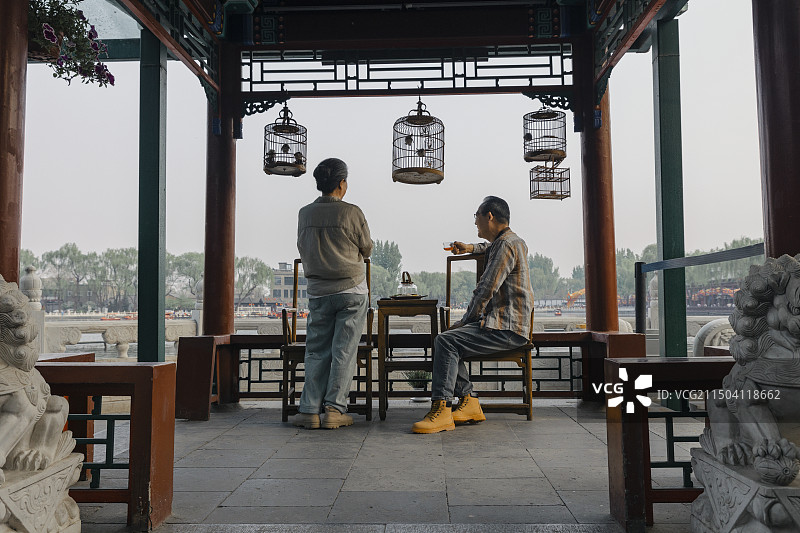 老年人City walk系列:老年夫妻在北京什刹海喝茶、聊天、看风景图片素材