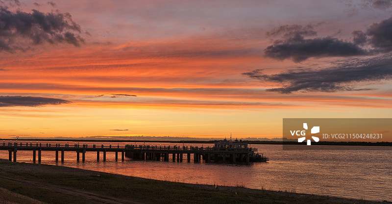 日落时江景映衬着戏剧性的天空：佳木斯市抚远市黑龙江畔图片素材