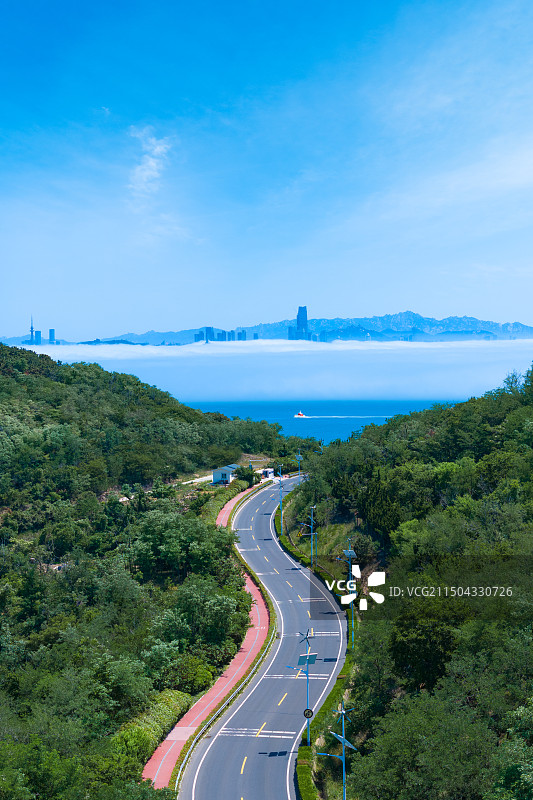 弯曲的公路尽头是云海中的城市图片素材