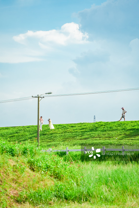 晴天在佛山市三水区北江大堤大草坪有人露营野餐有村民放牛图片素材