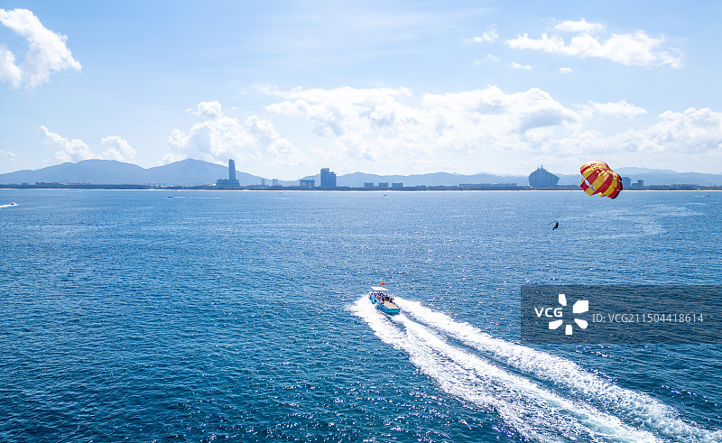 海南三亚蜈支洲岛水上旅游游玩项目空中拖伞与游艇航拍高视角唯美治愈蔚蓝色大海图片素材