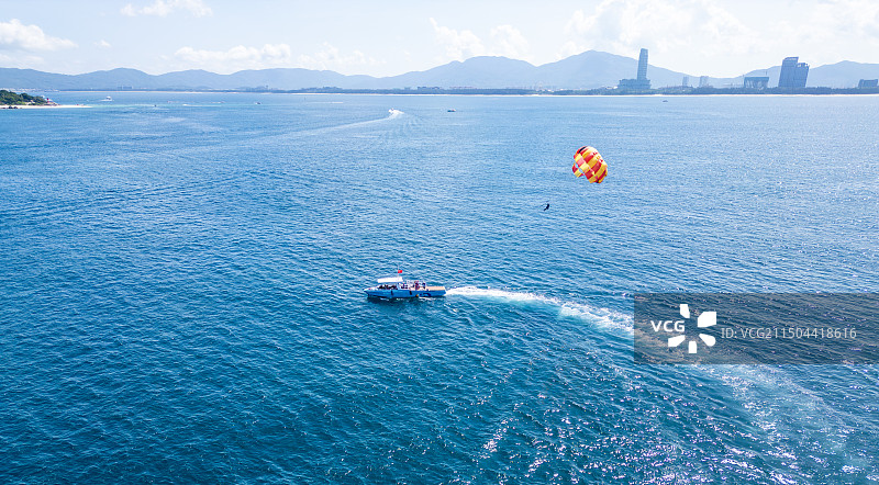 海南三亚蜈支洲岛水上旅游游玩项目空中拖伞与游艇航拍高视角唯美治愈蔚蓝色大海图片素材