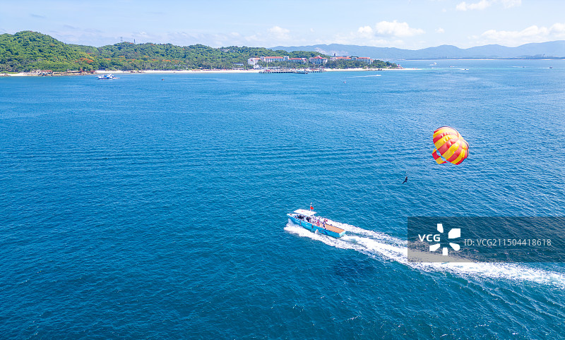 海南三亚蜈支洲岛水上旅游游玩项目空中拖伞与游艇航拍高视角唯美治愈蔚蓝色大海图片素材