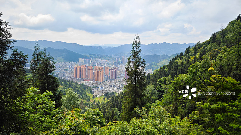 云南省昭通市威信县县城高空俯拍森林掩映下的城市图片素材