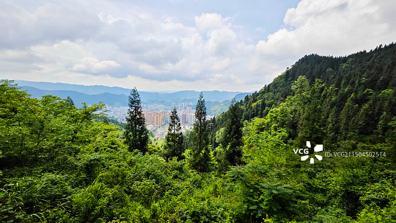 云南省昭通市威信县县城高空俯拍森林掩映下的城市图片素材