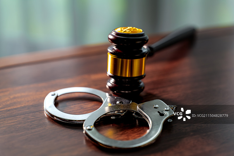 桌子上法槌和手铐的特写镜头图片素材