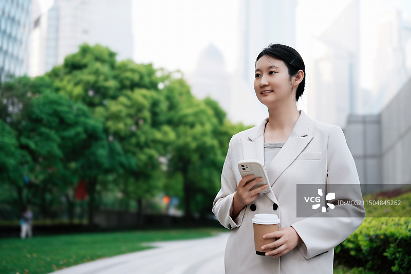 职业女性在城市公园检查电话图片素材
