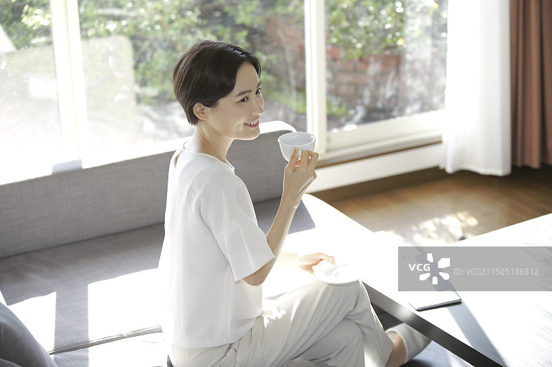 坐在沙发上喝咖啡的女人图片素材