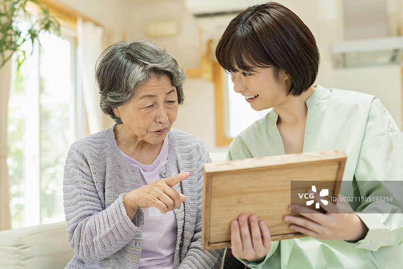 年长的女人和孙子孙女一起看照片图片素材