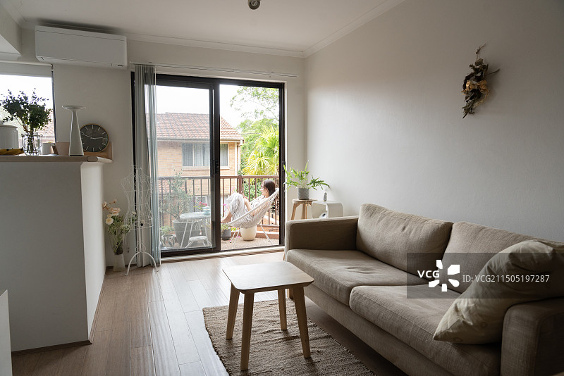 女人坐在阳台椅子上看手机图片素材