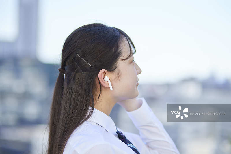 戴着无线耳机听音乐的高中女生图片素材